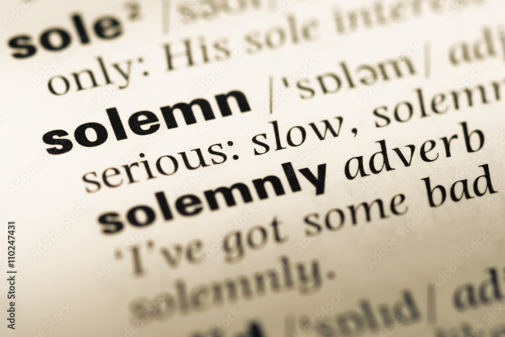 Close up of old English dictionary page with word solemn Close up of old English dictionary page with word solemn