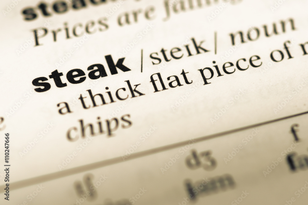 Close up of old English dictionary page with word steak Close up of old English dictionary page with word steak