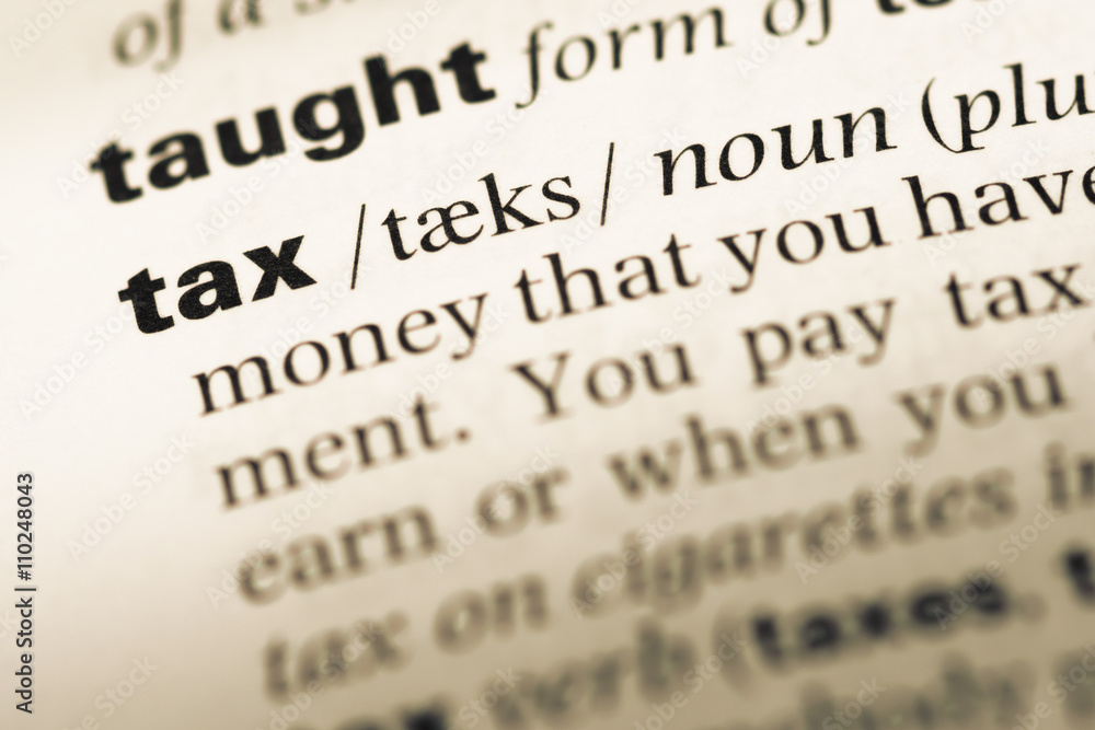 Close up of old English dictionary page with word tax Close up of old English dictionary page with word tax