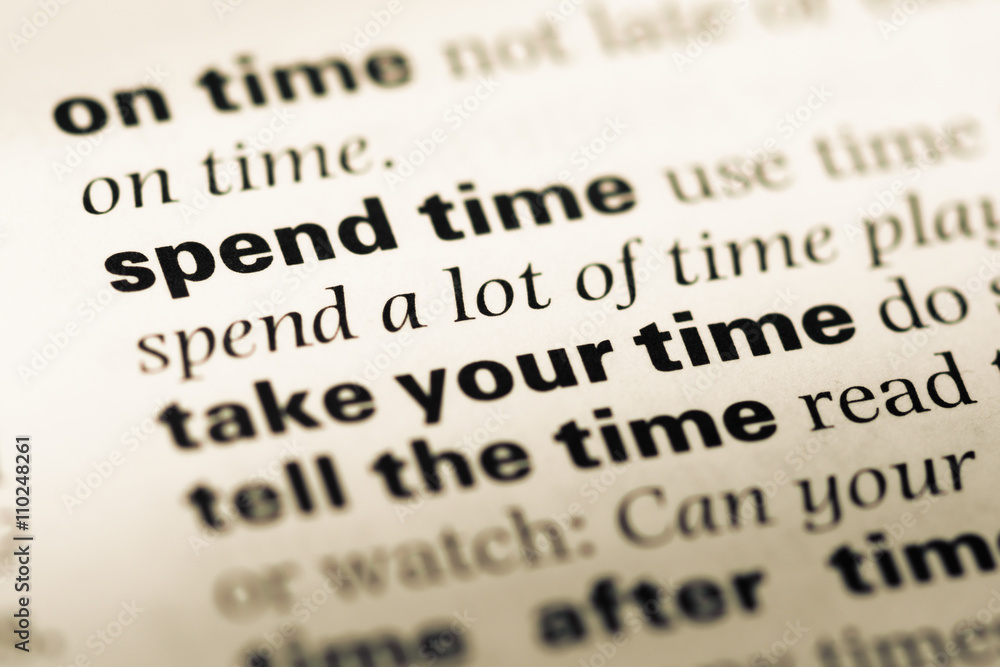 Close up of old English dictionary page with word spend time Close up of old English dictionary page with word spend time