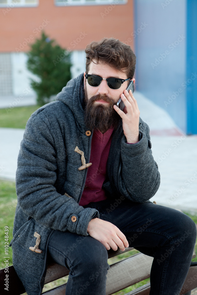 Young man with hipster look with the mobile Young man with hipster look with the mobile