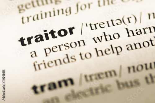 Photo Close up of old English dictionary page with word traitor