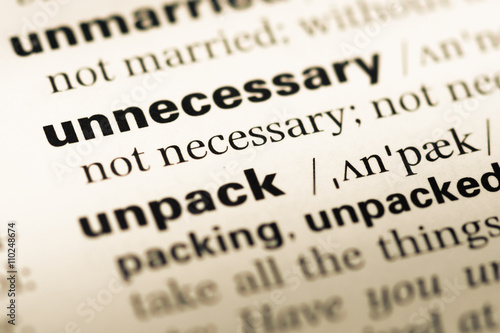 Close up of old English dictionary page with word unnecessary