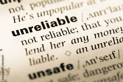 Close up of old English dictionary page with word unreliable