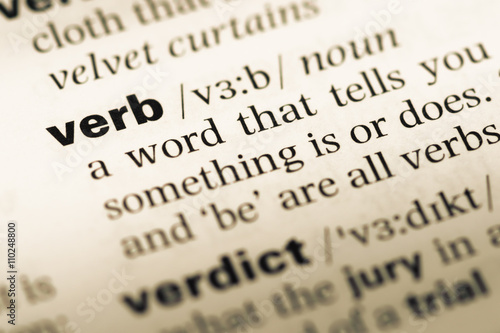 Close up of old English dictionary page with word verb