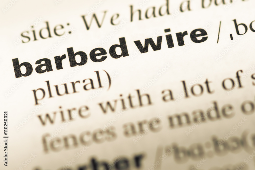 Fototapeta premium Close up of old English dictionary page with word barbed wire
