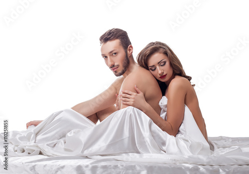 Erotica. Loving couple in bed, isolated on white