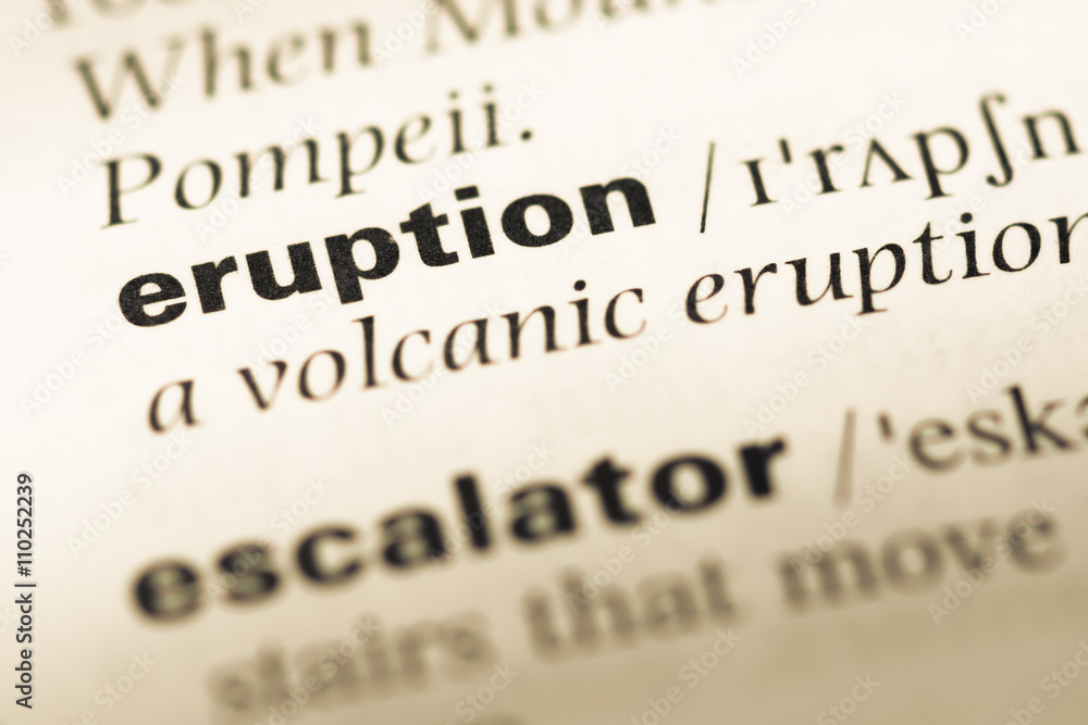 Close up of old English dictionary page with word eruption Close up of old English dictionary page with word eruption