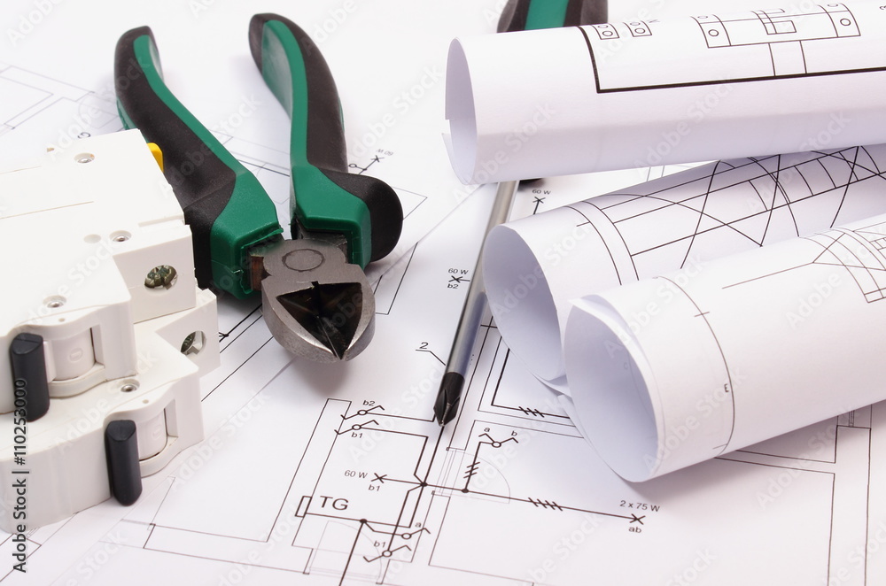 Work tools, electric fuse and rolls of diagrams on construction drawing of house Work tools, electric fuse and rolls of diagrams on construction drawing of house