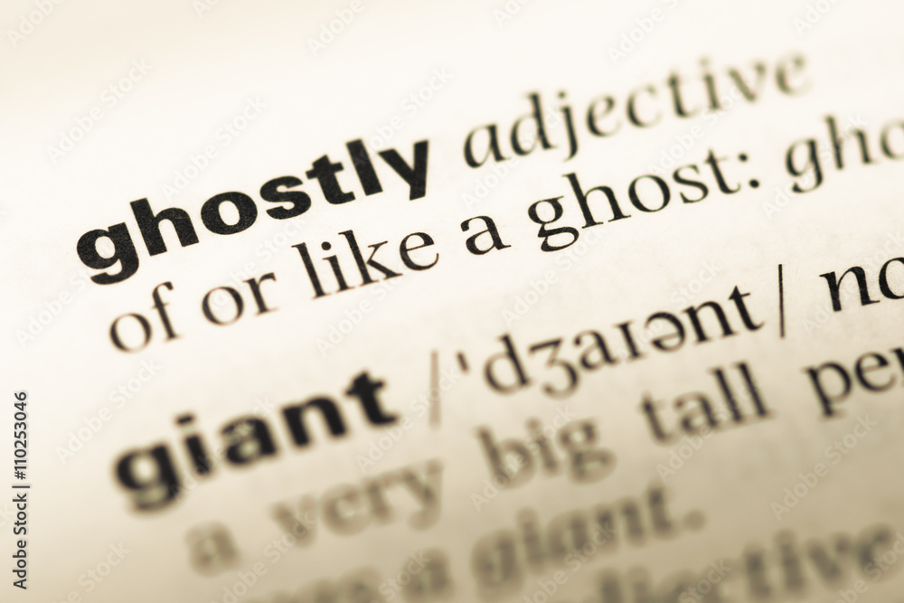 Close up of old English dictionary page with word ghostly Close up of old English dictionary page with word ghostly