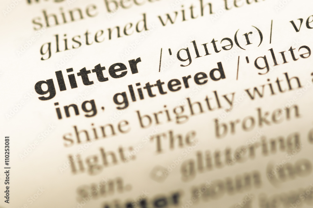 Close up of old English dictionary page with word glitter Close up of old English dictionary page with word glitter