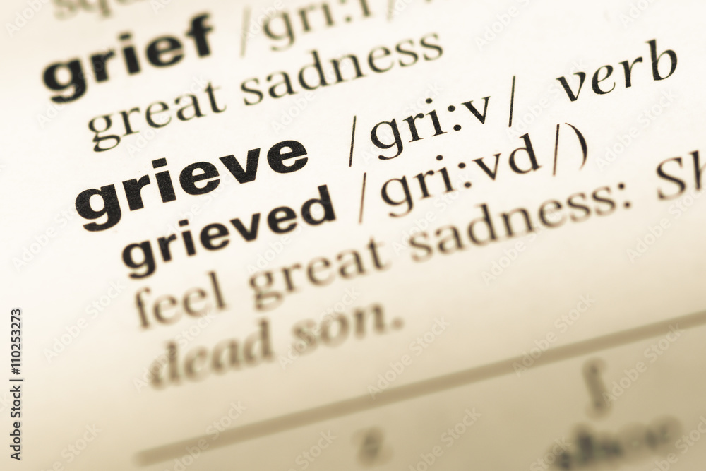 Close up of old English dictionary page with word grieve Close up of old English dictionary page with word grieve