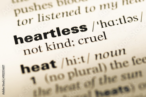 Close up of old English dictionary page with word heartless photo
