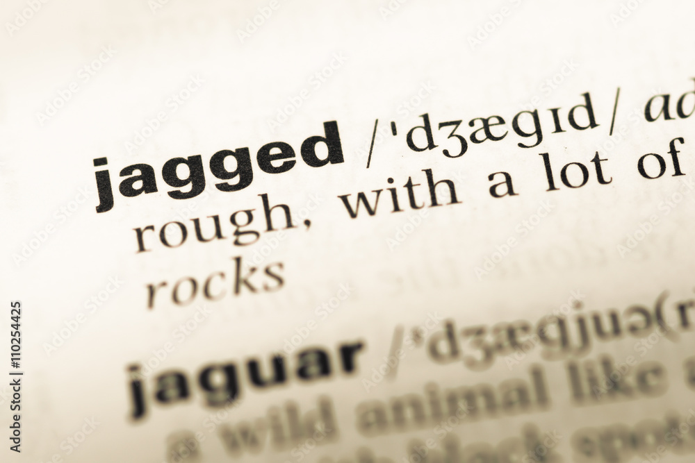 Fototapeta premium Close up of old English dictionary page with word jagged