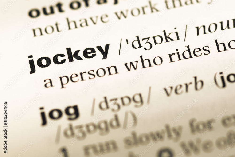 Close up of old English dictionary page with word jockey Close up of old English dictionary page with word jockey