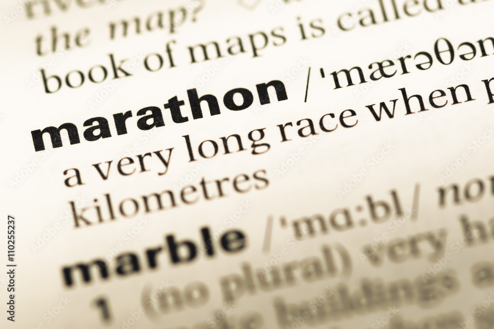 Close up of old English dictionary page with word marathon Close up of old English dictionary page with word marathon