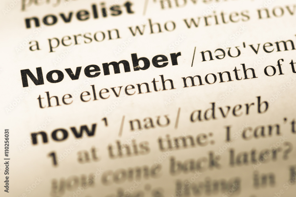 Close up of old English dictionary page with word november Close up of old English dictionary page with word november