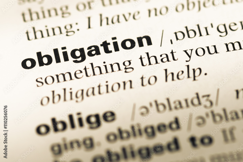 Obraz premium Close up of old English dictionary page with word obligation