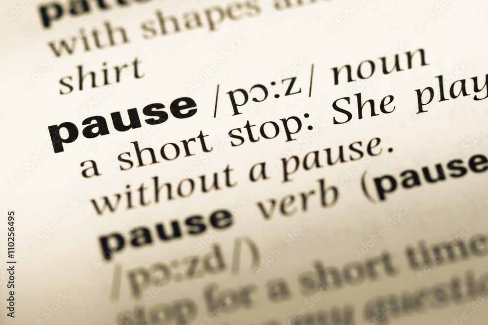 Close up of old English dictionary page with word pause Close up of old English dictionary page with word pause