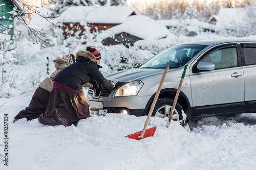two women pushing a car