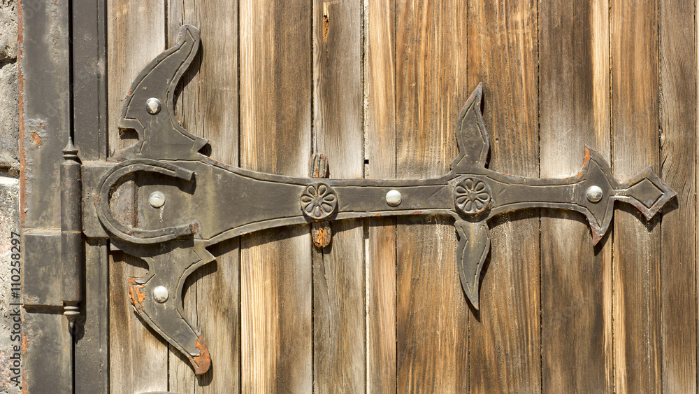 Gothic wrought iron elements on the wooden plank gate Gothic wrought iron elements on the wooden plank gate