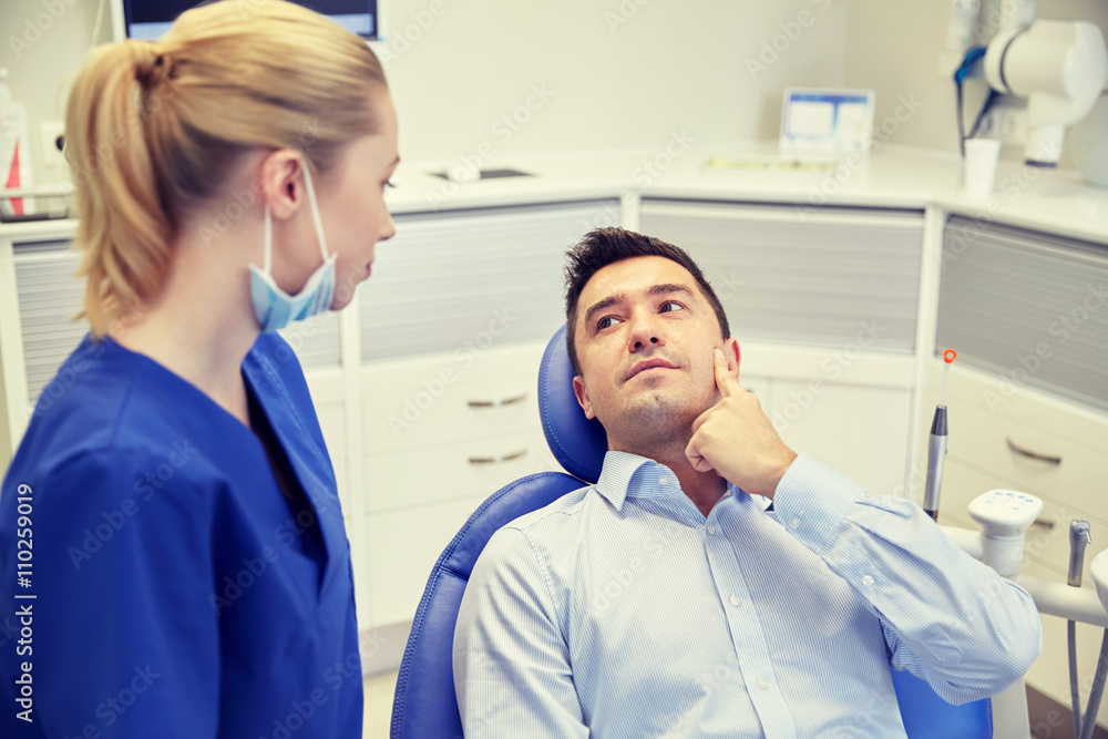 Fototapeta premium male dentist with woman patient at clinic