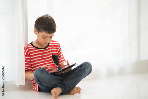 Little boy playing tablet at home