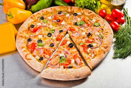 a delicious Italian pizza with bacon, olives and cheese with evenly cut piece