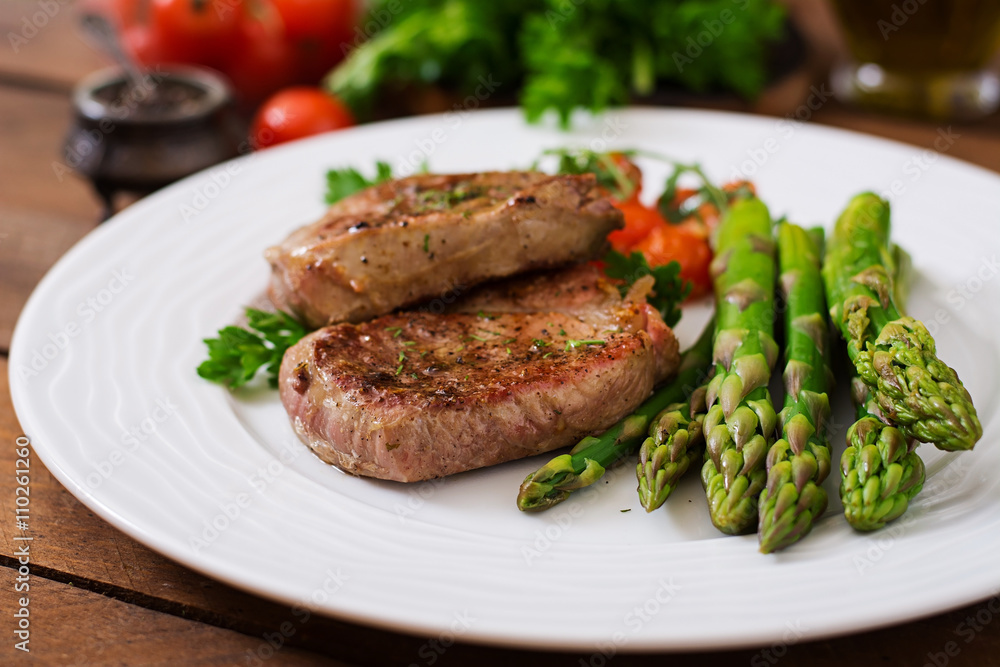 Barbecue grilled beef steak meat with asparagus and tomatoes.