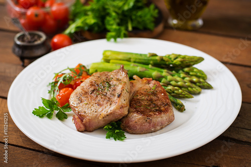 Barbecue grilled beef steak meat with asparagus and tomatoes.