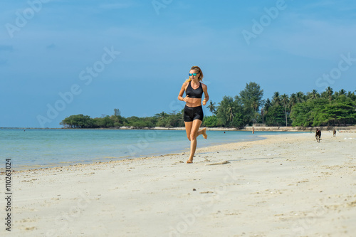 Young woman running on the beach 