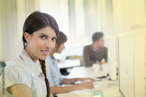 Portrait of young brunette woman working in office