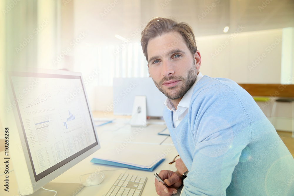 Portrait of businessman working on desktop computer