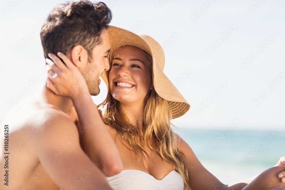 Fototapeta premium Young couple sitting on sand