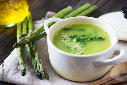 Creamy asparagus soup on wooden background