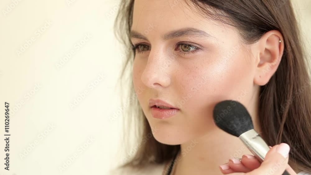 Master applies powder to model's face, professional makeup, powder brush Master applies powder to model's face, professional makeup, powder brush