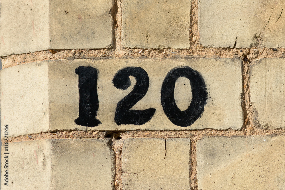 House Number 120 painted sign on wall House Number 120 painted sign on wall