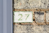 House Number 27 painted sign on wall