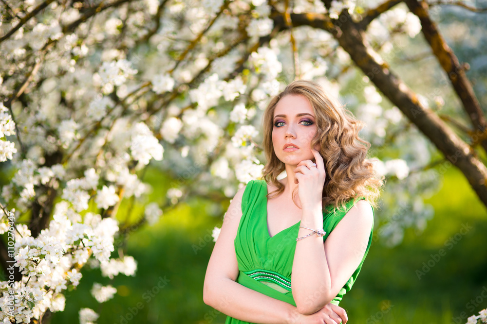 beautiful young blond woman standing beside a blossoming Apple tree beautiful young blond woman standing beside a blossoming Apple tree
