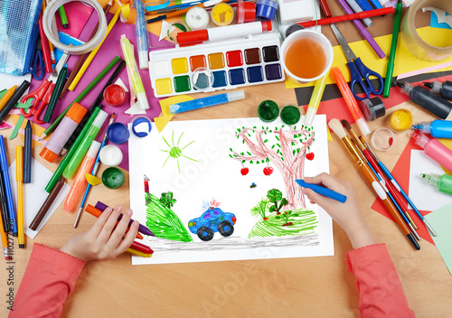 police car on outdoor, child drawing, top view hands with pencil painting picture on paper, artwork workplace