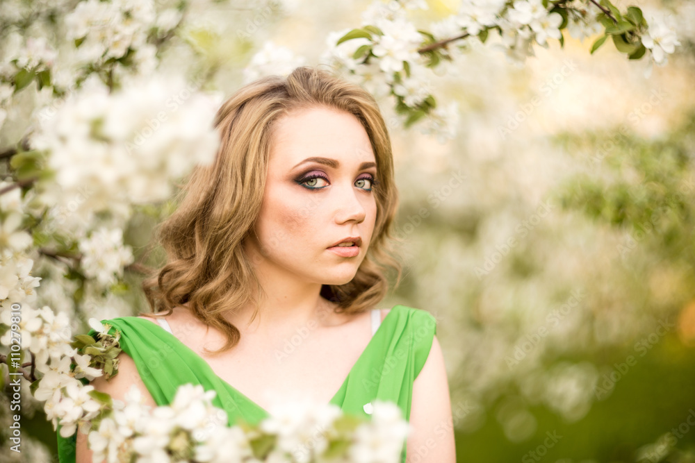 Beautiful happy young woman in spring blossoming garden Beautiful happy young woman in spring blossoming garden