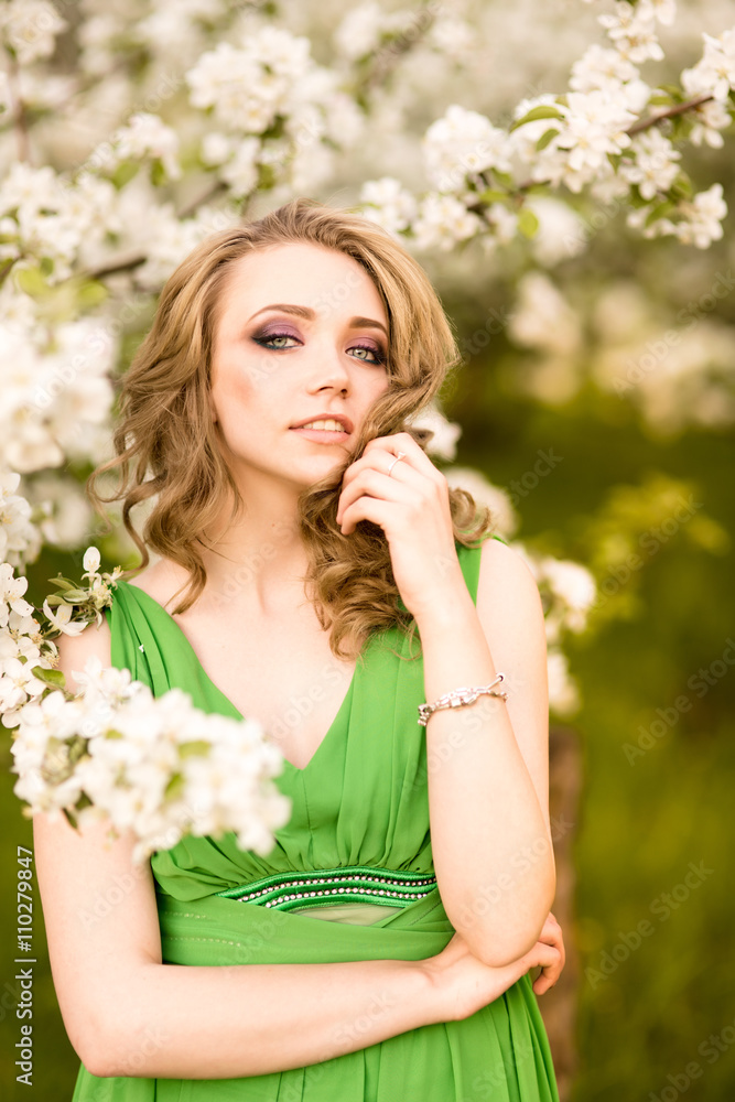 beautiful young blond woman standing beside a blossoming Apple tree beautiful young blond woman standing beside a blossoming Apple tree