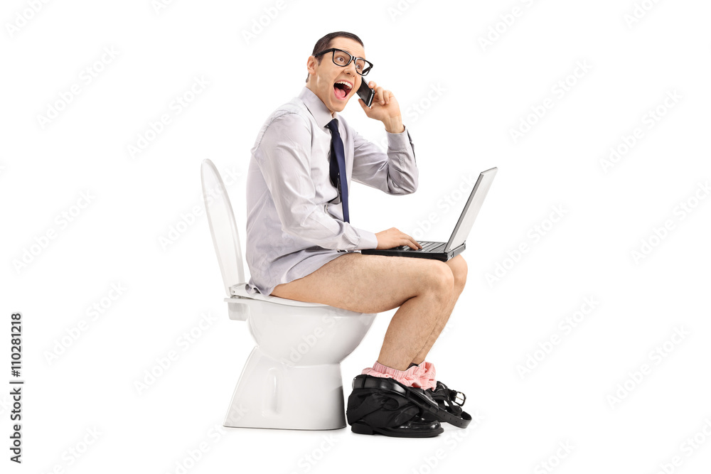 Businessman talking on phone in toilet Businessman talking on phone in toilet