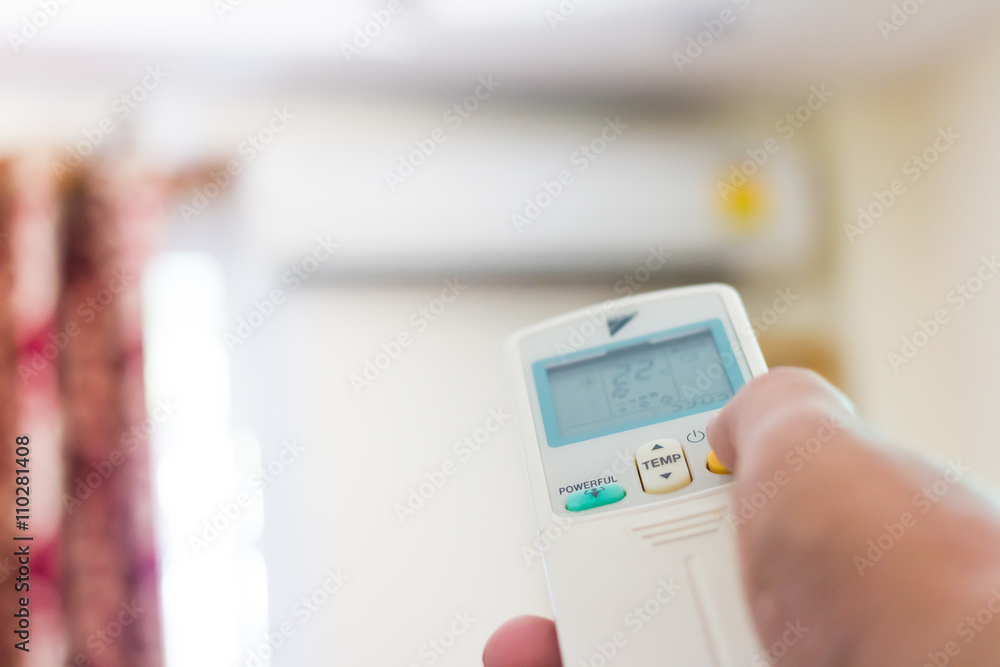 Hand using remote control of air condition, selective focus Hand using remote control of air condition, selective focus