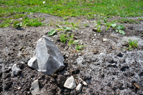 small rough bright stone lying on meadow ground 