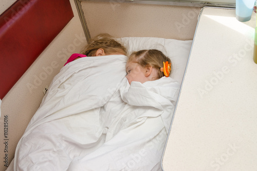 Photography Two children sleep on the train on the same ground location in the second-class