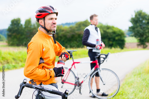 Two sport cyclists having break