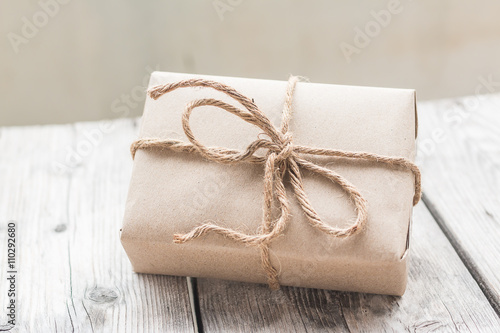 Vintage gift box brown paper wrapped with rope on wood backgroun
