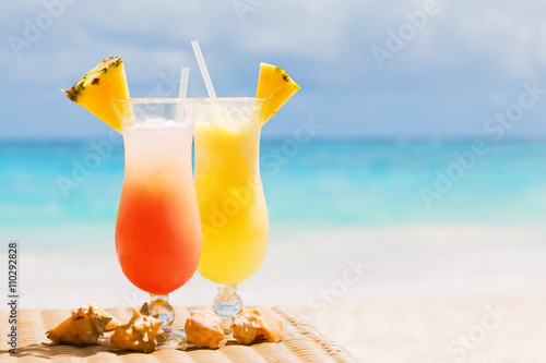 Fototapeta Naklejka Na Ścianę i Meble -  Two tropical fresh juices on white sandy beach