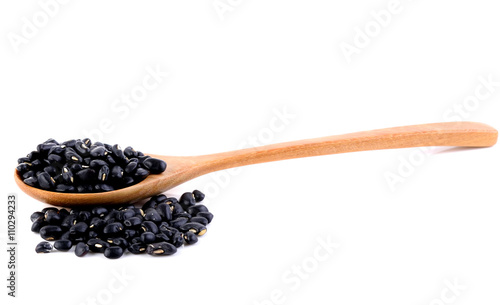 black beans in spoons on white background